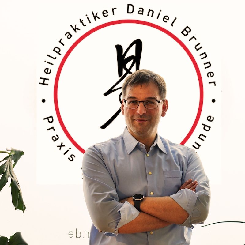 Heilpraktiker Daniel Brunner sitzt vor dem Fenster in seiner Praxis in Berlin-Moabit