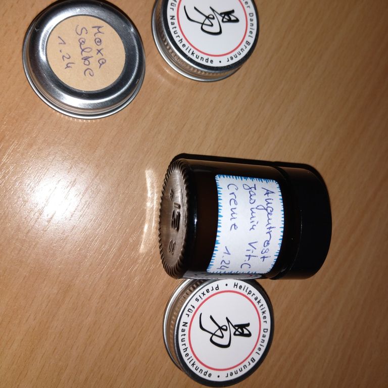 Salben in Dosen auf einem Tisch.